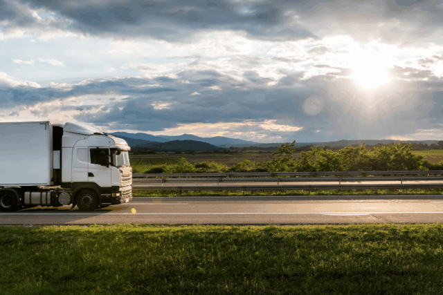 Truck driving along a road in the sunshine
